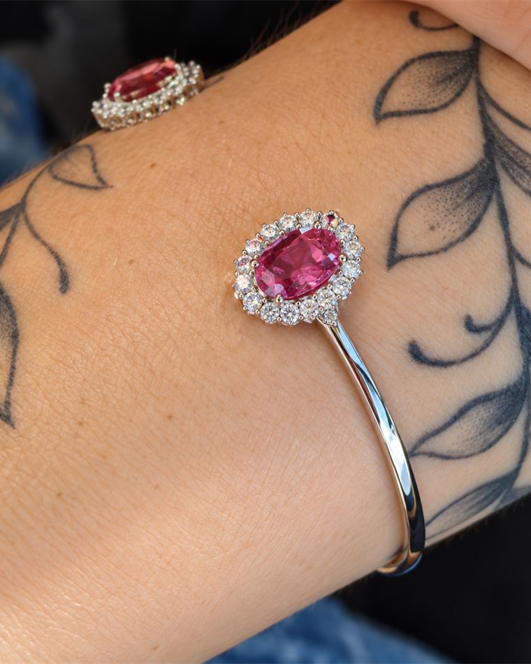 Open white gold bangle set with rose tourmalines in diamond halos